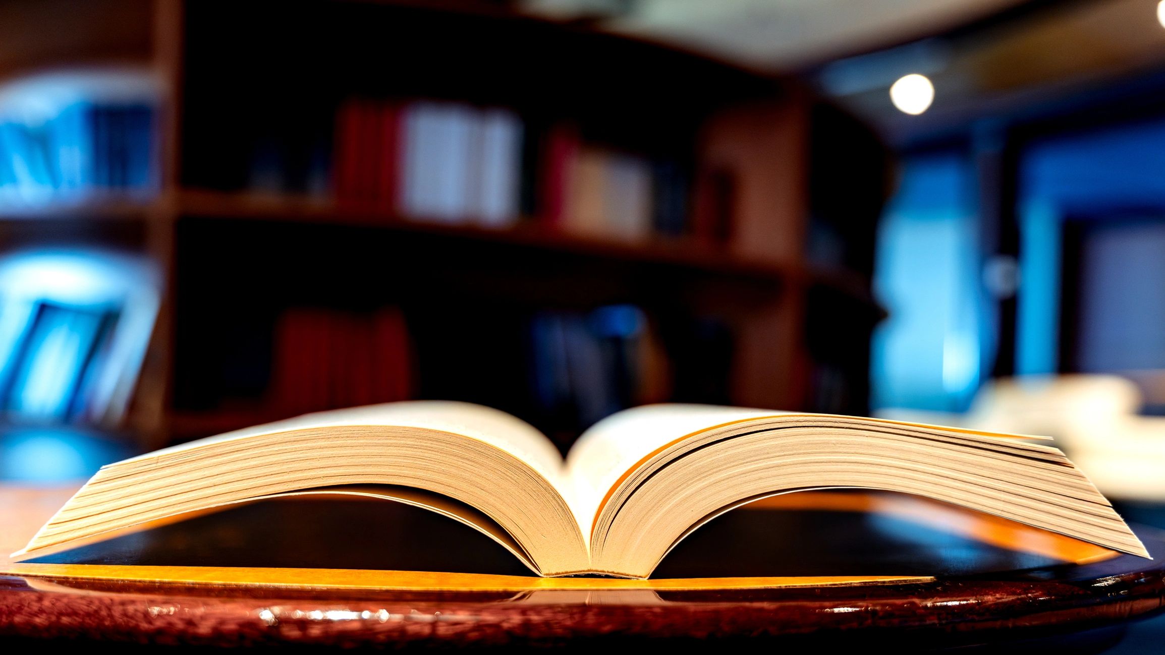 Open book resting on table in library studying literature